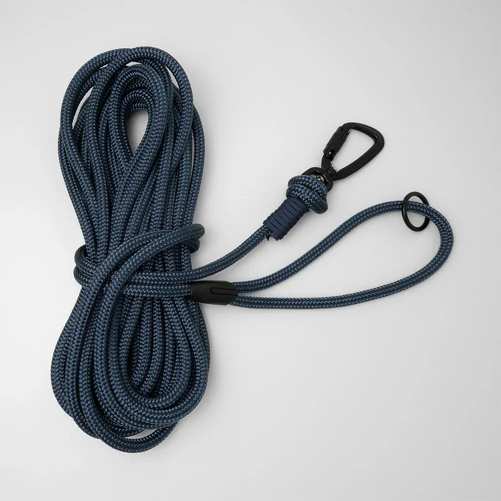 Navy blue long line dog training lead featuring black swivel carabiner and black O-ring, coiled on a white background