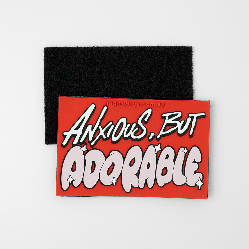Red and black patch with 'Anxious, But Adorable' text on a white background showing the hook and loop side