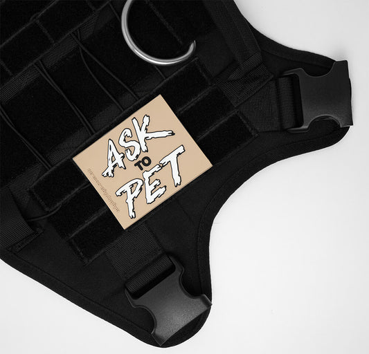 Black tactical dog harness with a patch that says 'Ask to Pet' on a white background