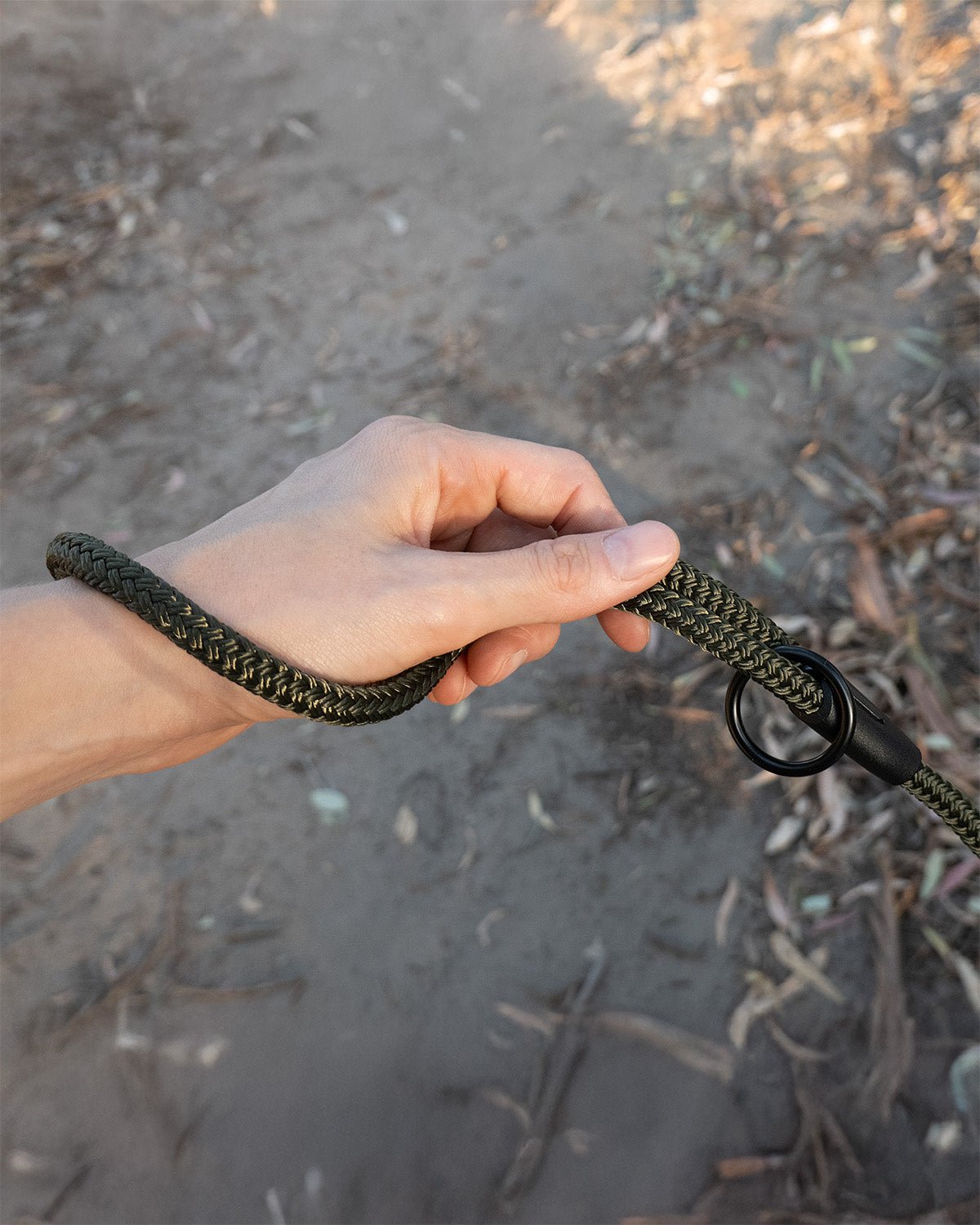 Close-up of long line training lead handle in army green, held in a hand, showing black O-ring