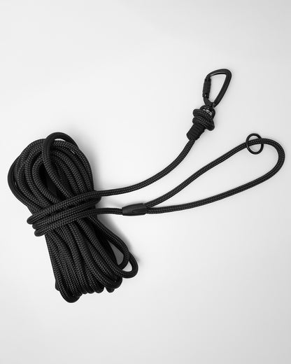 Black long line dog training lead featuring black swivel carabiner and black O-ring, coiled on a white background