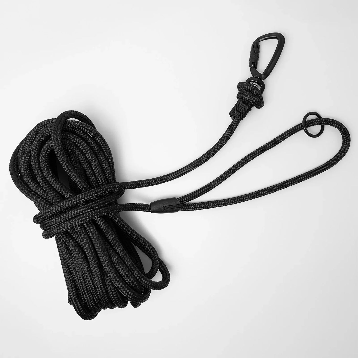 Black long line dog training lead featuring black swivel carabiner and black O-ring, coiled on a white background