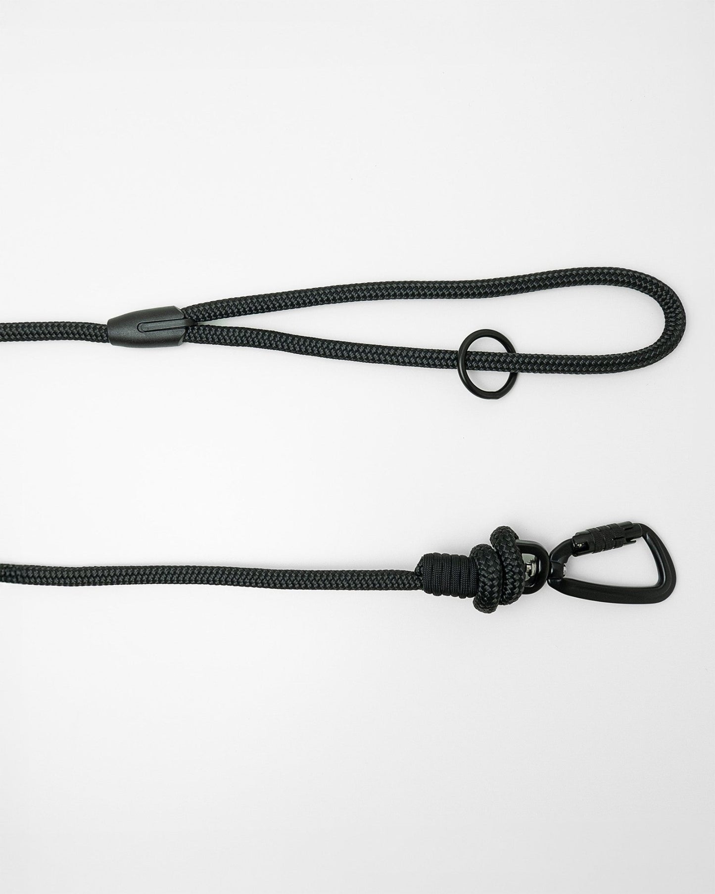 Detail view of long line dog training lead handle with black swivel carabiner and black O-ring hardware, shown in black on white background
