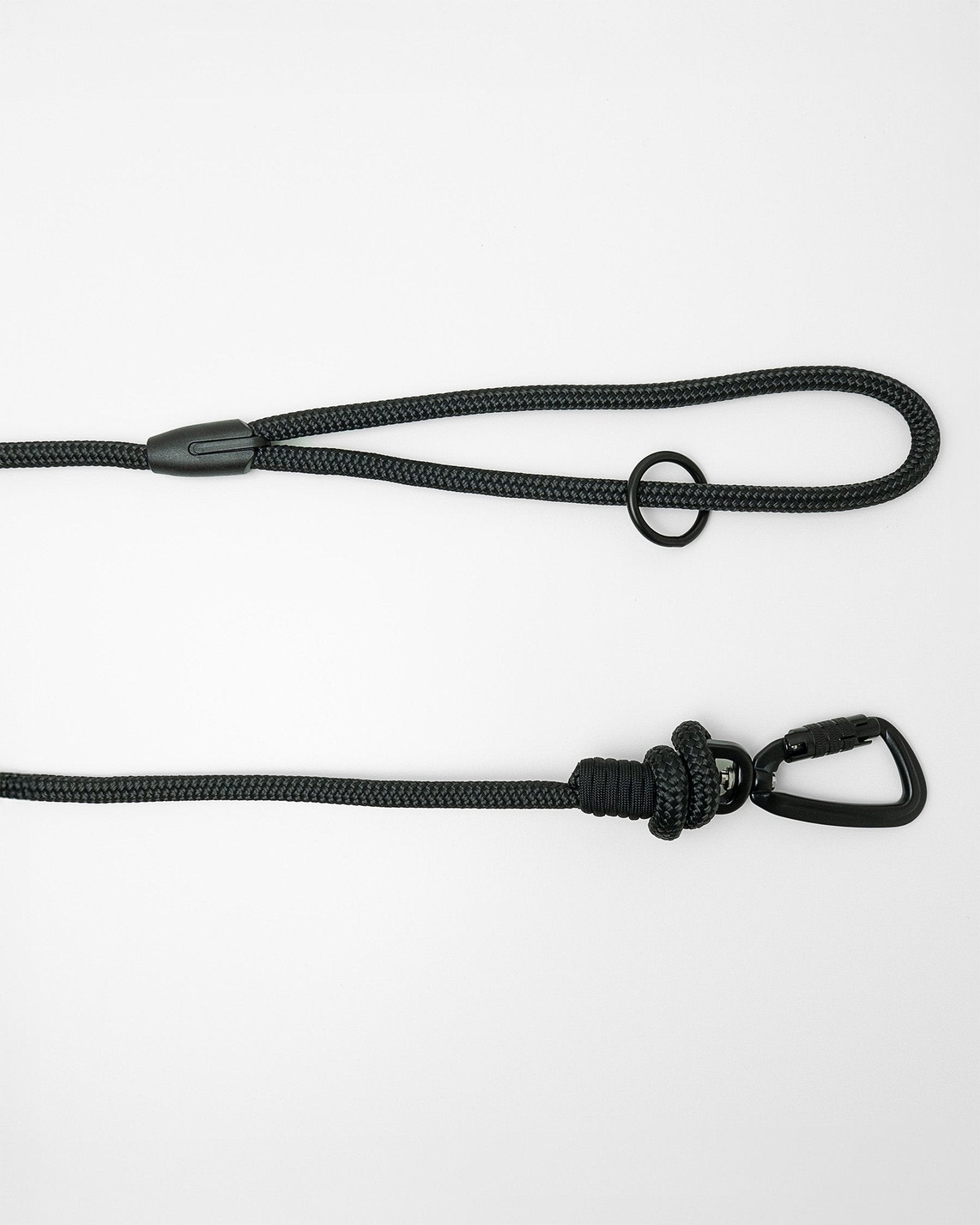 Detail view of long line dog training lead handle with black swivel carabiner and black O-ring hardware, shown in black on white background