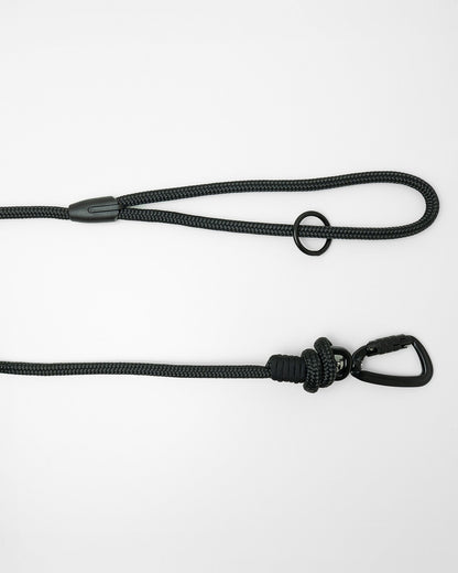 Detail view of long line dog training lead handle with black swivel carabiner and black O-ring hardware, shown in black on white background