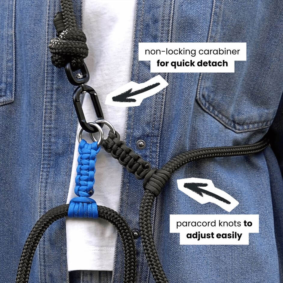 Close-up of a army green rope dog lead worn over a blue denim jacket and white shirt, with white text callouts explaining the non-locking carabiner and adjustable paracord knots.